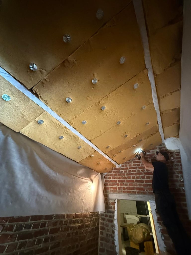 Plywood ceiling with metal fasteners and white trim in brick room under construction
