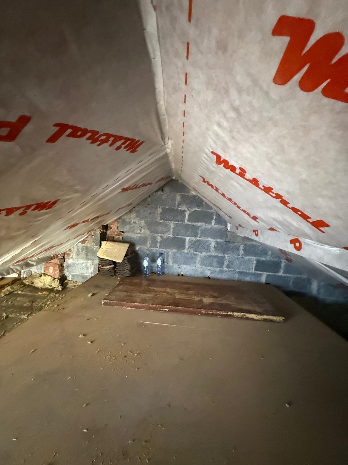 Werf met witte folie en bakstenen muur